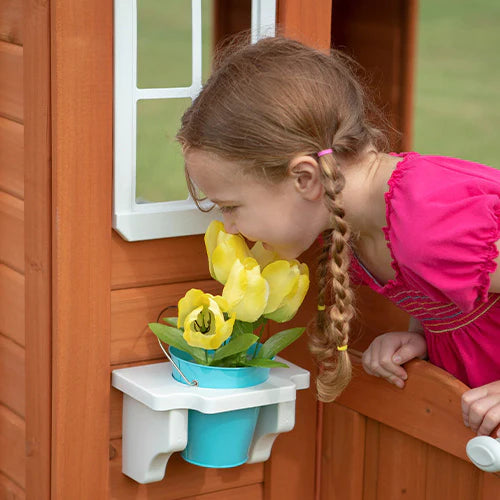 girl with fake flowers in playhouse